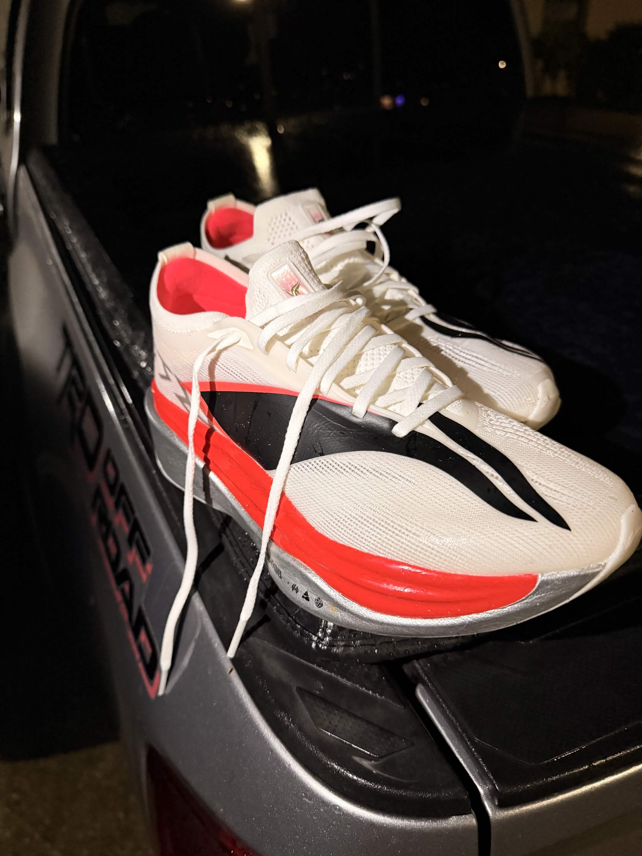 Li-Ning carbon-plated racing shoes on a truck tailgate at night.