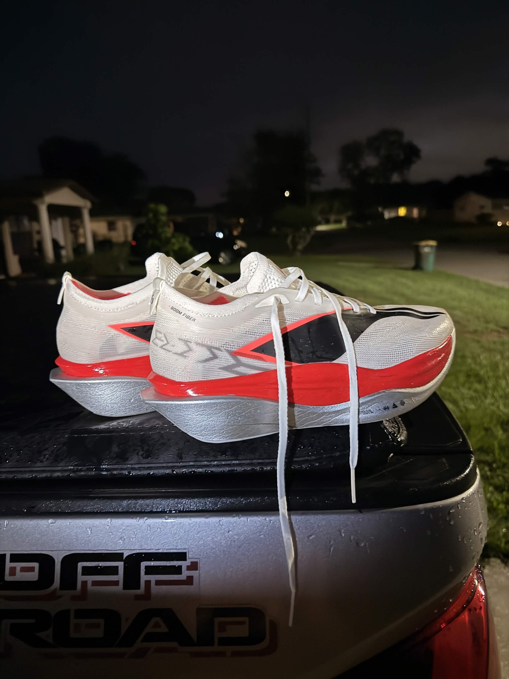 Li-Ning carbon-plated racing shoes on a truck tailgate at night.